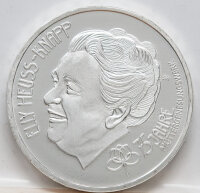 Runde Münze mit geprägtem Portraitprofil-Motiv, Spiegelnder Hintergrund mit matten Reliefs.